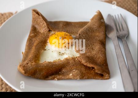 Galettes crêpes bretonnes à base de farine de sarrasin et servies avec des garnitures salées, du fromage fondu et des œufs en gros plan Banque D'Images