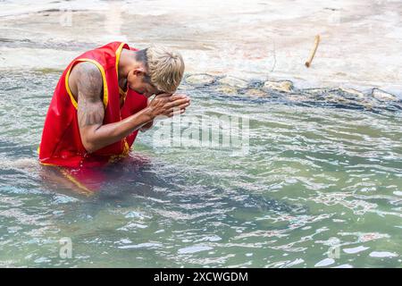 SAMUT PRAKAN, THAÏLANDE, MAI 26 2024, Tamer est assis sur un crocodile dans l'eau et prie avant de se produire Banque D'Images