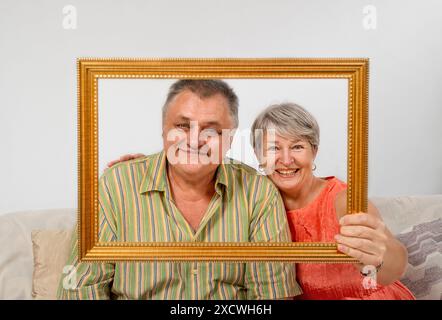 Cadre portrait d'un couple senior sur le canapé dans le salon Banque D'Images