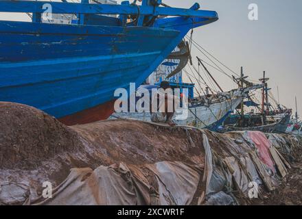 Jakarta, Indonésie - 9 mai 2024. Il est assis près de la goélette Phinisi à Sunda Kelapa. Harbor. Banque D'Images