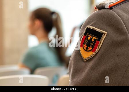 Bamberg, Allemagne. 17 juin 2024. Un soldat de la Bundeswehr est assis dans les rangs d'une classe scolaire. Les officiers de la jeunesse de la Bundeswehr viennent dans les écoles sur demande. En tant que conférenciers de l'éducation politique, ils fournissent des informations sur la politique de sécurité et l'importance des soldats. Crédit : Pia Bayer/dpa/Alamy Live News Banque D'Images