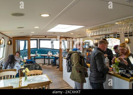 Les clients à l'intérieur du café restaurant Barge Tearoom amarrés sur le canal historique de Bude à Bude en Cornouailles au Royaume-Uni. Banque D'Images