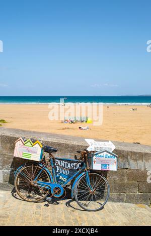 Un vieux vélo utilisé pour faire de la publicité sur la plage de Towan à Newquay en Cornouailles au Royaume-Uni. Banque D'Images