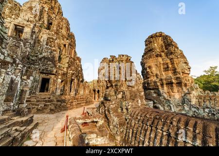 Ruines mystérieuses de l'ancien temple du Bayon à Angkor Thom dans le soleil du soir. Incroyable Angkor Thom niché dans la forêt tropicale à Siem Reap, Cambodge. Banque D'Images