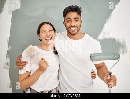 Couple heureux, portrait et peinture ensemble pour la rénovation de la maison comme partenaire pour l'amélioration de la maison. Femme, homme et design d'intérieur avec des outils Banque D'Images