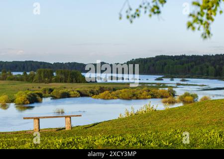 Photo de paysage rural russe avec un banc en bois vide debout au sommet du mont Savkina sur la côte de la rivière Sorot par une journée d'été ensoleillée Banque D'Images