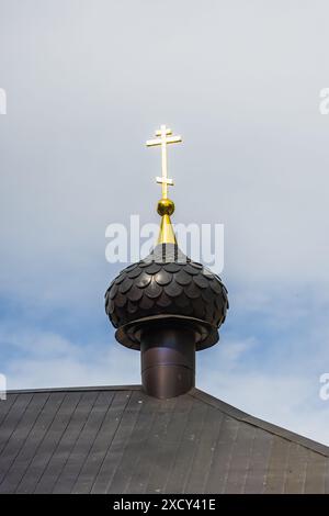 La croix dorée se trouve au sommet de l'église orthodoxe russe par une journée ensoleillée Banque D'Images