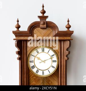 Une horloge de grand-père antique fixée au mur en bois avec des chiffres romains et une porte en verre sur un fond de surface blanche - rendu 3D. Banque D'Images