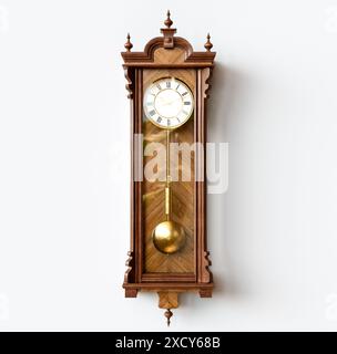 Une horloge de grand-père antique fixée au mur en bois avec des chiffres romains et une porte en verre sur un fond de surface blanche - rendu 3D. Banque D'Images