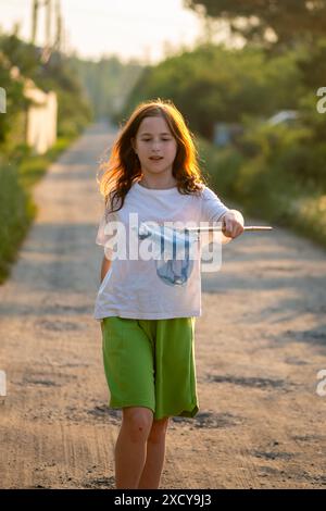 Jolie fille attrapant des papillons avec un filet en été, heure d'été, vacances, plaisir d'été Banque D'Images