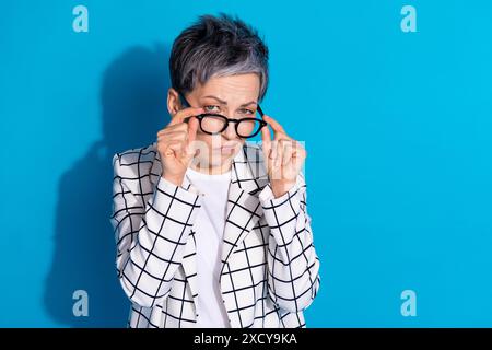 Photo de femme suspecte d'esprit porter des vêtements élégants à la mode décision hmm isolé sur fond de couleur bleue Banque D'Images