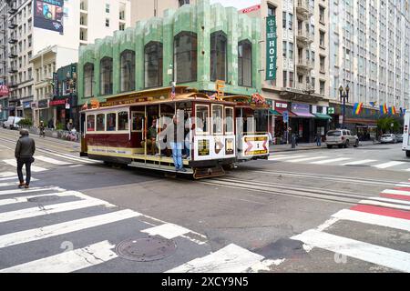 San Francisco, Californie, États-Unis d'Amérique - 13 juin 2024 : un téléphérique traditionnel à San Francisco sur la ligne Powell-Hyde traverse un carrefour très fréquenté de la ville dans l'état de Californie *** Eine traditionelle téléphérique à San Francisco auf der Powell-Hyde Linie, durchquert eine belebte Kreuzung in der Stadt im Bundesstaat Kalifornien Banque D'Images