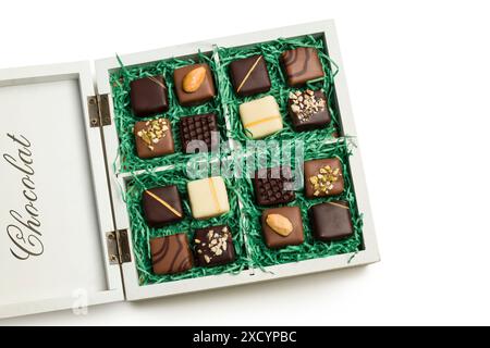 Chocolats assortis dans une boîte cadeau en bois sur fond blanc. Banque D'Images