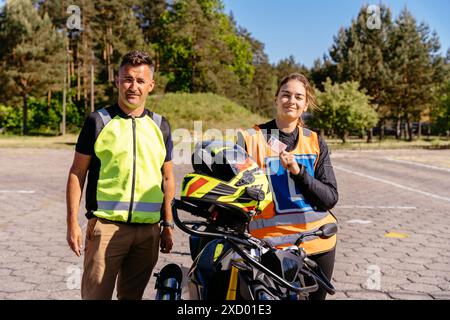 Un homme et une femme sont debout à côté d'une moto Banque D'Images