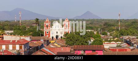 Vue panoramique depuis le toit de la cathédrale blanche de la ville coloniale Leon au Nicaragua en Amérique centrale. Regardant l'église du Calvaire doux nom de Jésus avec volcan en arrière-plan. Banque D'Images