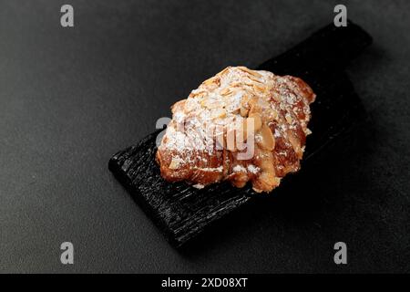 Croissant aux amandes. pâte feuilletée, délicate crème frangipane aux amandes, enrichie de beurre. Sur le dessus, le croissant a un soupçon de flocons d'amande et de pow Banque D'Images