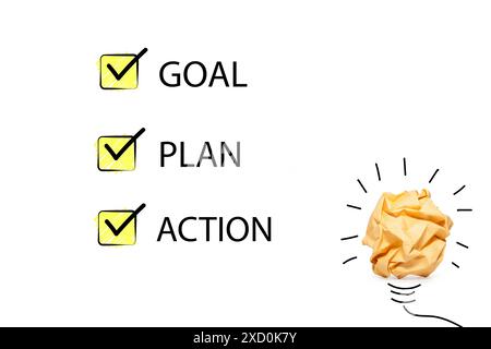 Un fond blanc avec une boule de papier jaune dessus. La boule de papier est entourée de trois cases à cocher, chacune étiquetée avec un objectif différent : objectif, plan, Banque D'Images