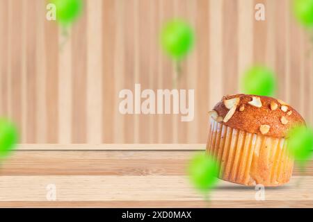 Muffin aux amandes sur une table en bois avec des ballons verts flous. Copier l'espace. Banque D'Images