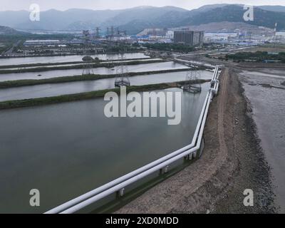(240619) -- NANJING, 19 juin 2024 (Xinhua) -- Une photo de drone prise le 19 juin 2024 montre les pipelines du projet Heqi no 1 dans la centrale nucléaire de Tianwan dans la ville de Lianyungang, dans la province du Jiangsu, dans l'est de la Chine. La Chine a mené à bien un projet visant à transporter la vapeur produite par une centrale nucléaire vers une base pétrochimique. Le projet est conçu pour aider à réduire les émissions de carbone et explorer l'utilisation collaborative de l'énergie dans les industries nucléaires et traditionnelles. POUR ALLER AVEC 'China Focus : la Chine explore les applications de l'énergie nucléaire dans la réduction des émissions de carbone dans la pétrochimie Banque D'Images