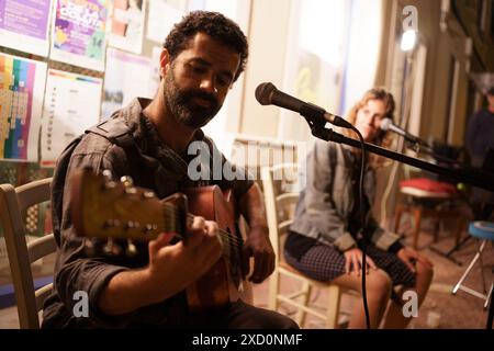 Es Castell, Espagne. 14 juin 2024. Un homme est vu chanter et jouer de la guitare pour les touristes et les habitants dans un bar dans le port de la ville. Plus de 90 millions de touristes devraient visiter l'Espagne en 2024, dont beaucoup se rendront aux îles Baléares, un nombre record, ce qui en fait le deuxième pays le plus visité au monde. (Photo de Davide Bonaldo/Sipa USA) crédit : Sipa USA/Alamy Live News Banque D'Images