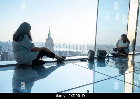 New York, États-Unis. 18 juin 2024. Une femme regarde l'Empire State Building depuis la plate-forme d'observation Summit One Vanderbilt à New York, aux États-Unis, le 18 juin 2024. L'attraction emmène les visiteurs au 93ème étage, au-dessus de gratte-ciel emblématiques comme l'Empire State Building et le Chrysler Building. One Vanderbilt se dresse comme un gratte-ciel superhaut à l'angle de la 42nd Street et Vanderbilt Avenue dans le quartier Midtown Manhattan de New York. (Photo de Aashish Kiphayet/NurPhoto) crédit : NurPhoto SRL/Alamy Live News Banque D'Images