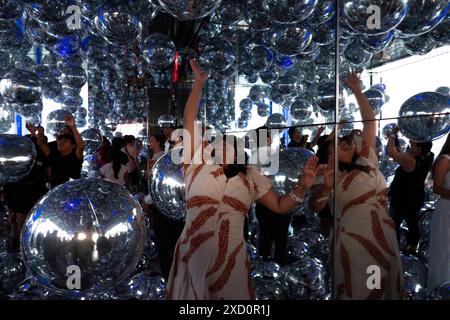 New York, États-Unis. 18 juin 2024. Une femme fait rebondir des ballons argentés en Mylar à ''Affinity'' sur le pont d'observation Summit One Vanderbilt à New York, aux États-Unis, le jeudi 18 juin 2024. Le Summit One Vanderbilt est décrit comme un véritable pays des merveilles d’expériences sensorielles. Kenzo Digital, l’artiste qui conçoit chaque pièce, utilise des miroirs pour réfléchir et réfracter la ville qui entoure le bâtiment. Des ballons argentés en mylar entourent le spectateur dans cette pièce dans une installation appelée ''Affinity''. (Photo de Aashish Kiphayet/NurPhoto) crédit : NurPhoto SRL/Alamy Live News Banque D'Images