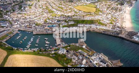 Paysage aérien de la pittoresque ville de pêcheurs de Cornouailles de Porthleven en Cornouailles avec port et crique protégeant une flotte de bateaux de pêche dans la popula Banque D'Images