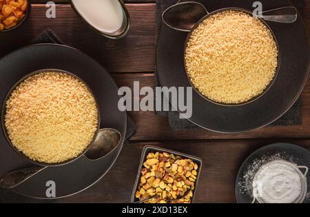 Cuisine arabe ; vue de dessus pour bols de couscous ordinaire. Servi avec des noix, du sucre et du babeurre. Banque D'Images