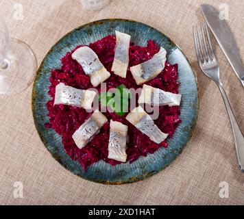 Sur l'oreiller de salade de betteraves - des morceaux de hareng légèrement salé sont disposés en cercle Banque D'Images