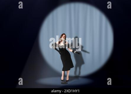 Belle chanteuse jouant sous les projecteurs sur scène Banque D'Images