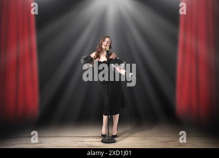 Belle chanteuse jouant sous les projecteurs sur scène Banque D'Images