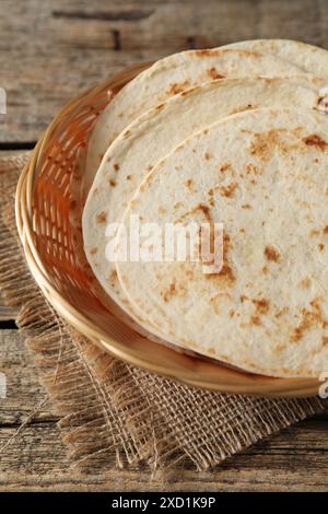 Tortillas maison savoureuses dans un panier en osier sur une table en bois Banque D'Images