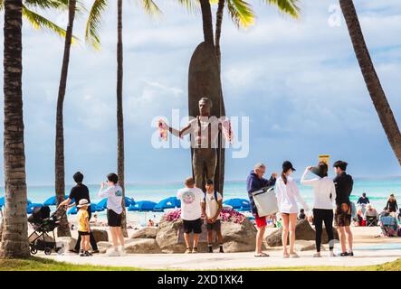 Touristes se rassemblant autour de la statue du duc Paoa Kahanamoku prenant des photos à Waikiki Beach. Banque D'Images