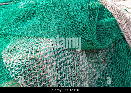Filets de pêche sur le quai. Tas de filets de pêche posés sur le sol, outils essentiels pour la capture de poissons Banque D'Images