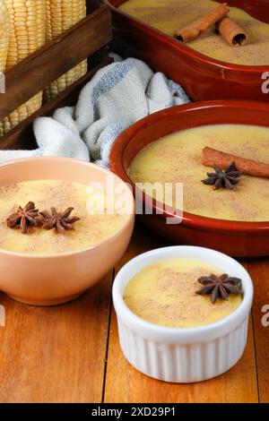 Curau, crème de maïs sucré et dessert typique de la cuisine brésilienne, placé dans un bol en céramique sur une table en bois. Gros plan Banque D'Images