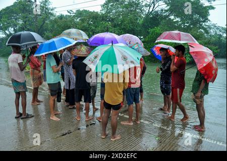 Non exclusif : les personnes avec des parapluies couvrent la pluie sur l'autoroute Sylhet-Bholaganj. La plupart des upazilas de Sylhet ont été submergés par le cont Banque D'Images