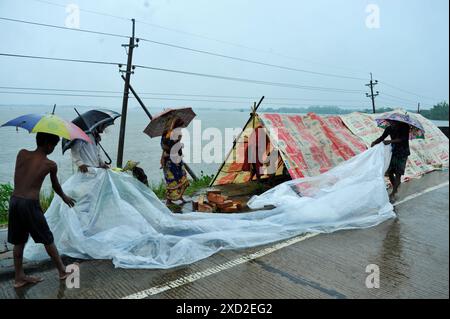 Non exclusif : les personnes avec des parapluies couvrent la pluie sur l'autoroute Sylhet-Bholaganj. La plupart des upazilas de Sylhet ont été submergés par le cont Banque D'Images