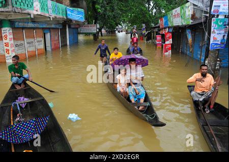 Non exclusif : les personnes avec des parapluies couvrent la pluie sur l'autoroute Sylhet-Bholaganj. La plupart des upazilas de Sylhet ont été submergés par le cont Banque D'Images