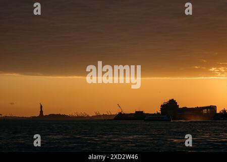 Port de New York au coucher du soleil avec Statue de la liberté au loin Banque D'Images