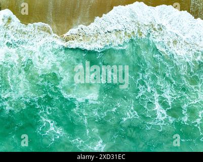 Vue aérienne turquoise tempête vagues océaniques avec de la mousse blanche dans l'océan, eau de mer avec des éclaboussures et de la mousse, fond de vagues vue de dessus, arrière-plan naturel Banque D'Images