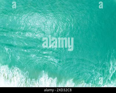 Vue aérienne turquoise tempête vagues océaniques avec de la mousse blanche dans l'océan, eau de mer avec des éclaboussures et de la mousse, fond de vagues vue de dessus, arrière-plan naturel Banque D'Images