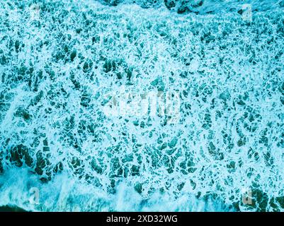 Vue aérienne turquoise tempête vagues océaniques avec de la mousse blanche dans l'océan, eau de mer avec des éclaboussures et de la mousse, fond de vagues vue de dessus, arrière-plan naturel Banque D'Images