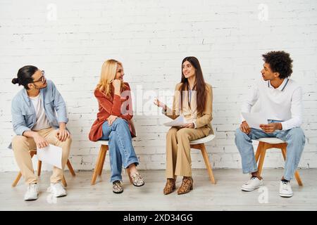 Groupe diversifié s'engageant dans des discussions animées tout en étant assis dans des chaises. Banque D'Images