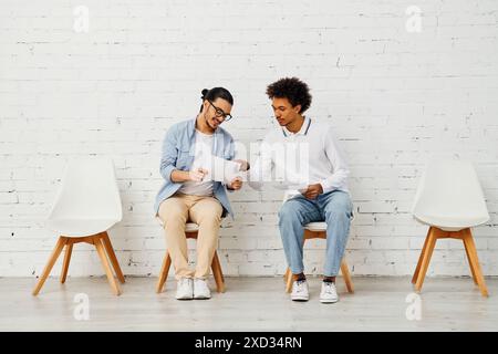 Deux personnes se sont engagées dans une conversation animée alors qu'elles étaient assises sur des chaises. Banque D'Images