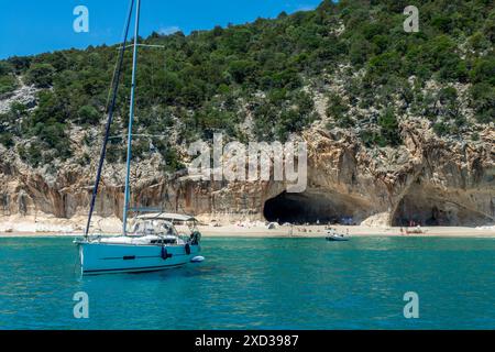 Bateau à voile à la plage de Cala Luna et eau bleue transparente claire dans le golfe d'Orosei, île de Sardaigne, Italie Banque D'Images