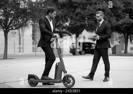 L'homme d'affaires se réunit sur son scooter électrique. Le scooter permet de gagner une journée pour le dernier homme d'affaires. Un homme d'affaires évite d'être en retard avec un scooter électrique Banque D'Images