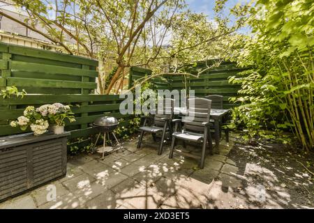 Un espace de jardin tranquille et accueillant avec des sièges extérieurs confortables, une végétation luxuriante et un barbecue, niché au Haarlemmerweg 207 Banque D'Images