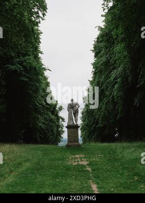 Une statue solitaire dans une avenue d'arbres dans les jardins du château de Chirk à Wrexham, pays de Galles, Royaume-Uni Banque D'Images