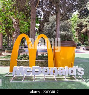 Bakou, Azerbaïdjan - 5 mai 2024 : une grande arche dorée McDonalds et un stand de coupe dans un parc de la rue Nizami Banque D'Images