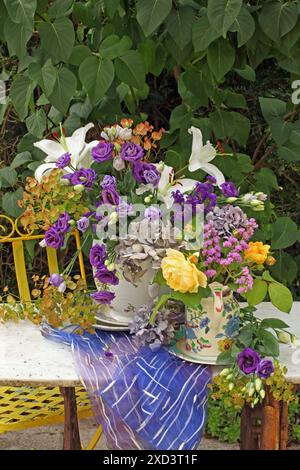 Botanique, eustoma grandiflorum, lys, roses et hortensia en porcelaine pichets sur une table en marbre à l'extérieur., EXTRA-RIGHTS-CLEARANCE-INFO-NOT-AVAILABLE Banque D'Images